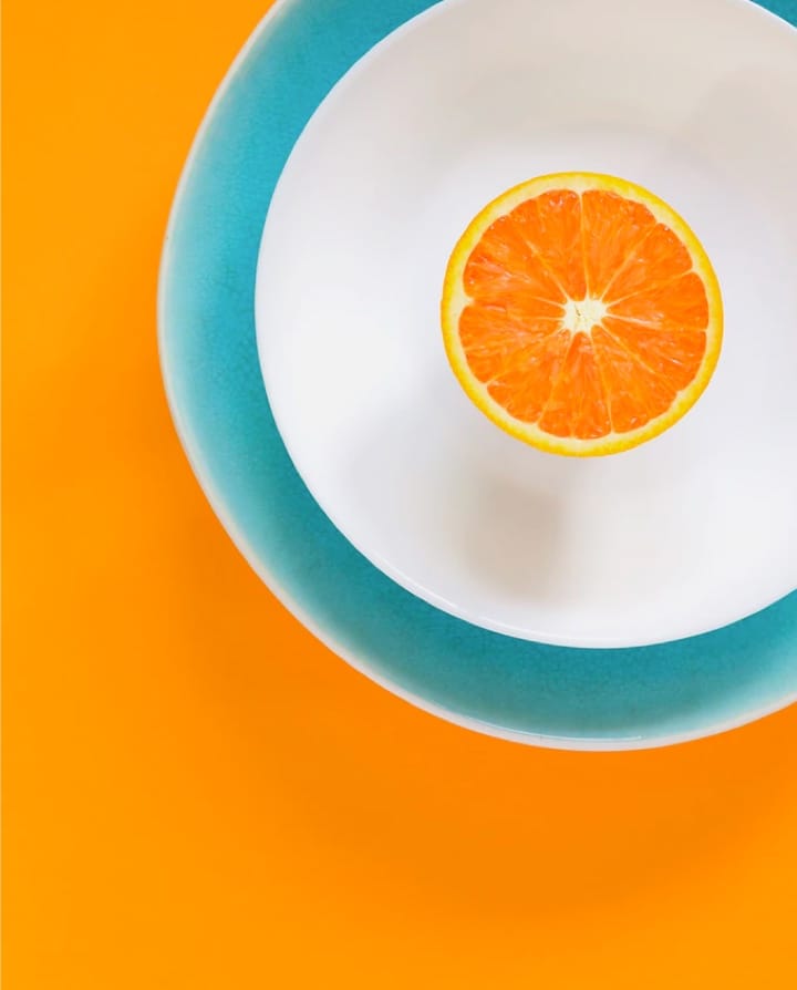 an orange in a white plate